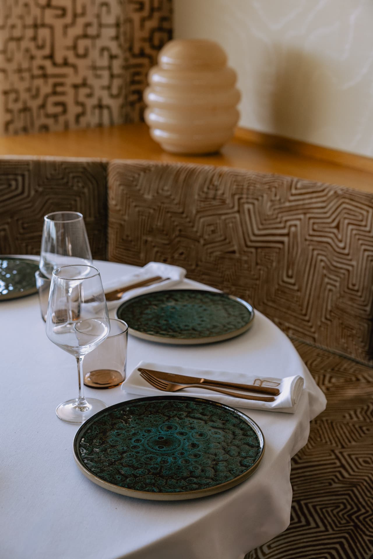 Main Restaurant — banquette seating with textured fabrics and ceramic plates